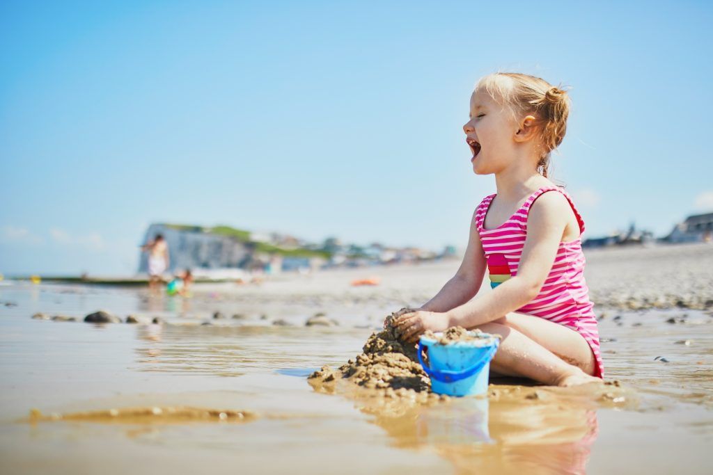 Une petite fille bretonne joue sur la plage