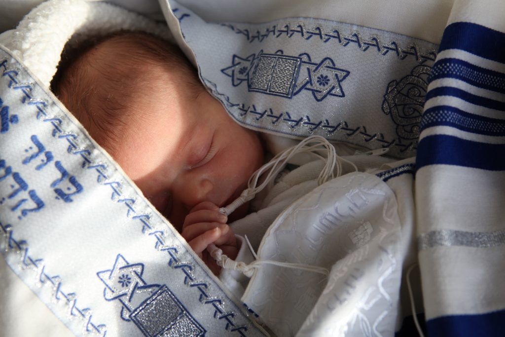 Un bébé qui dort, englobé dans des vêtements aux couleurs d'Israël