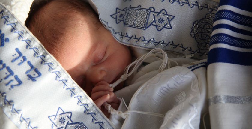 Un bébé qui dort, englobé dans des vêtements aux couleurs d'Israël